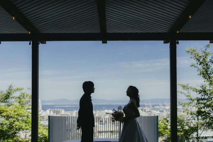 SOLA KOBE のテラスから神戸の街と海を望むおふたり